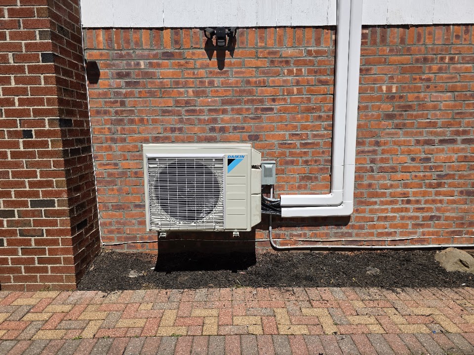 Same Daikin ductless outdoor unit raised on a wall bracket with lines enclosed in line-hide