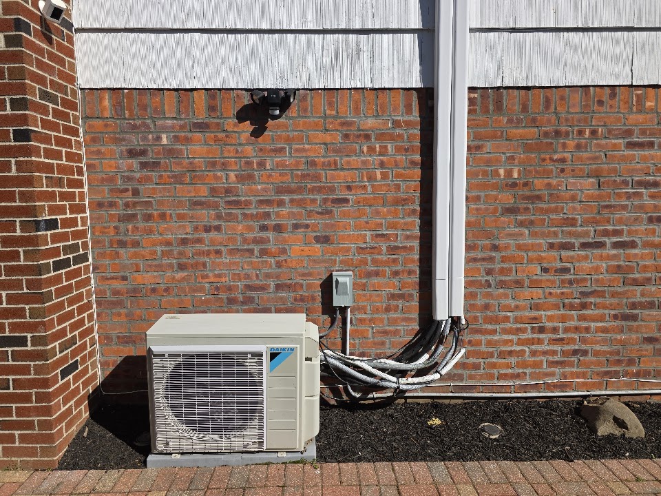 Existing Daikin ductless outdoor unit with exposed lines before cleanup